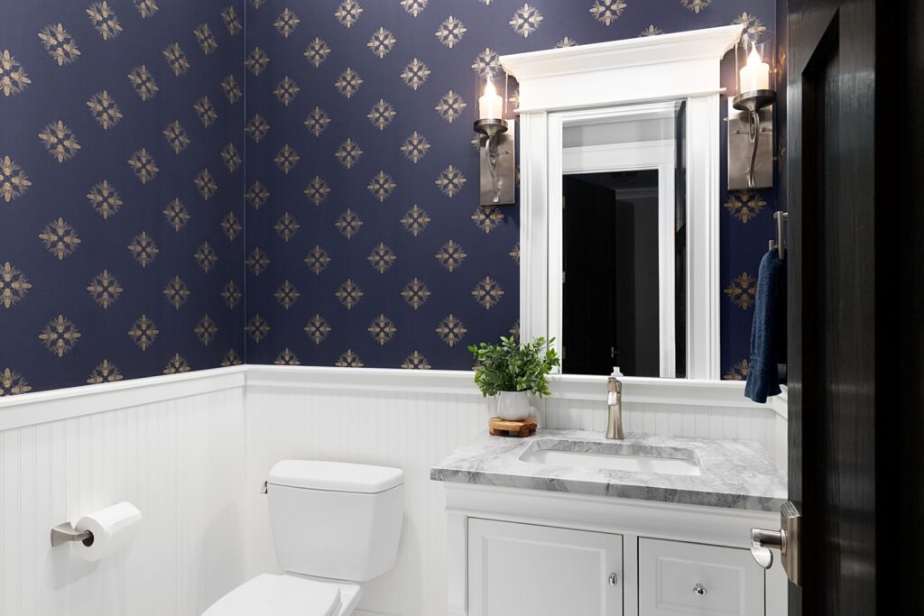 A bathroom with blue and gold wallpaper,