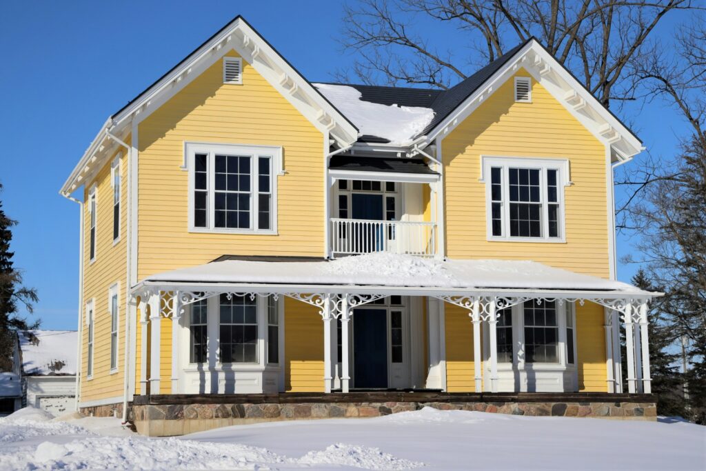 bright yellow house in snow