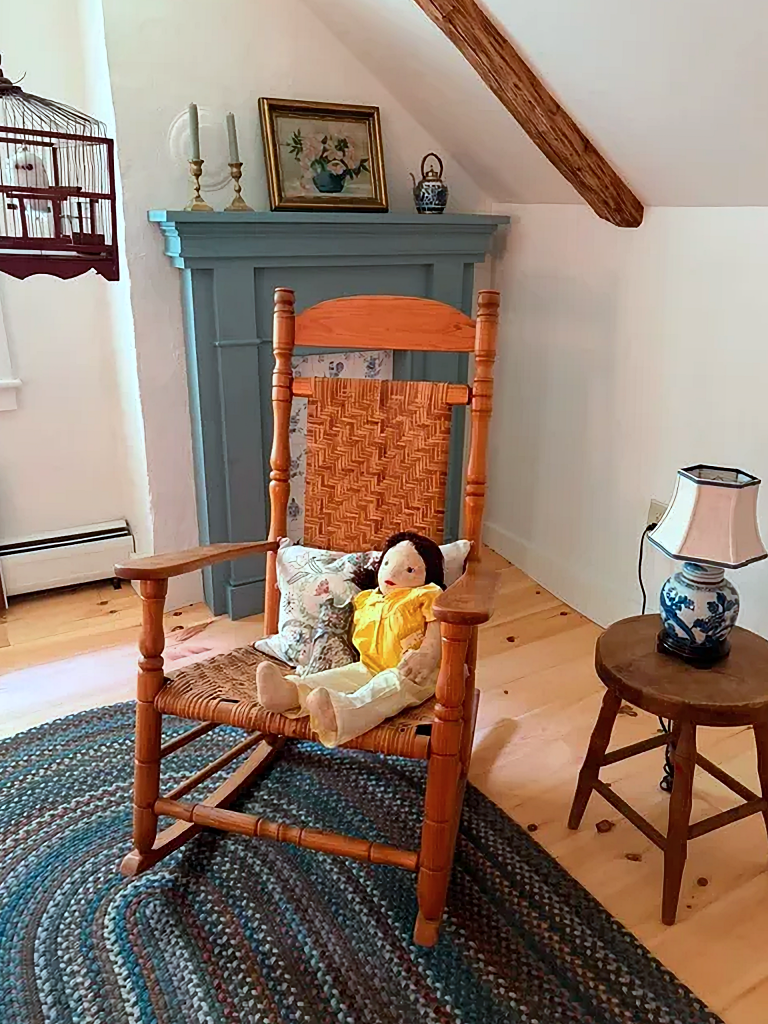 rocking chair in bedroom with antique doll